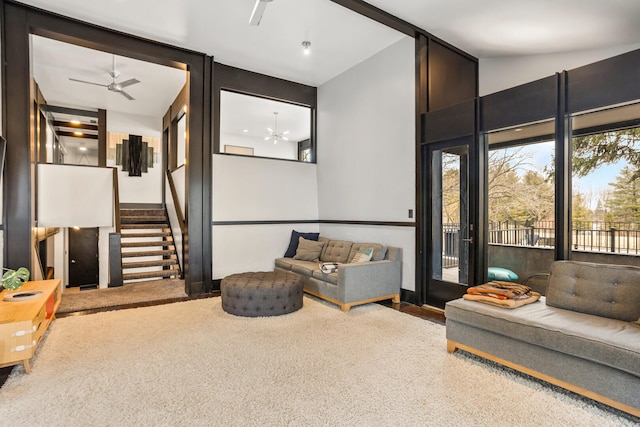 living area featuring stairway, carpet flooring, lofted ceiling with beams, and a ceiling fan