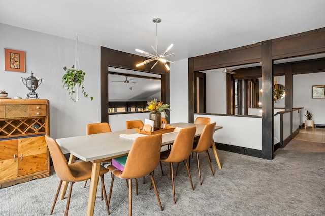 carpeted dining room featuring ceiling fan with notable chandelier and baseboards