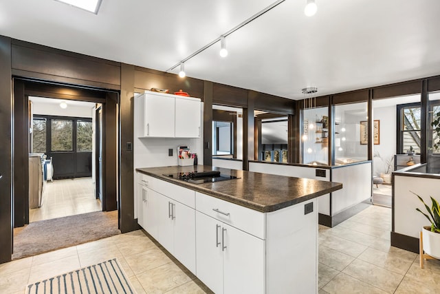 kitchen featuring dark countertops, a peninsula, black electric cooktop, and separate washer and dryer