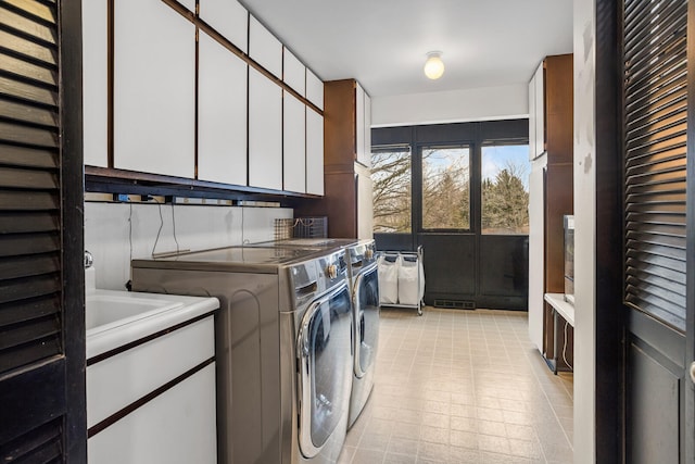 laundry room with visible vents, cabinet space, and separate washer and dryer