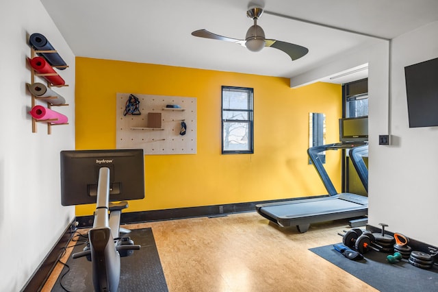 exercise area with plenty of natural light, baseboards, and a ceiling fan