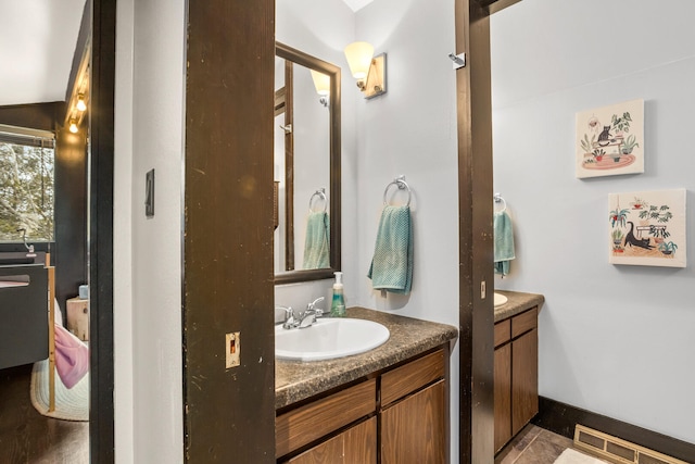 bathroom featuring vanity, baseboards, and visible vents