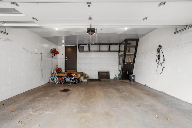 garage with concrete block wall and a garage door opener