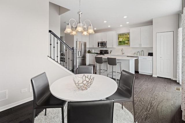 dining room with a notable chandelier, recessed lighting, baseboards, stairs, and dark wood-style floors