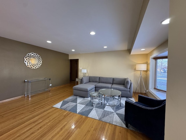 living area with baseboards, wood finished floors, and recessed lighting