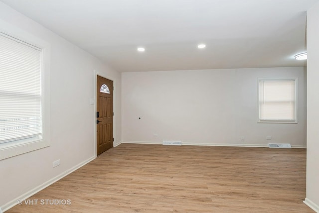 unfurnished room with light wood finished floors, recessed lighting, visible vents, and baseboards