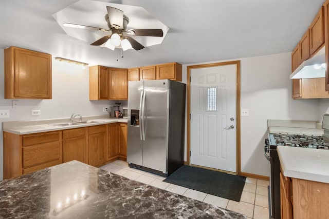 kitchen featuring light tile patterned floors, black range with gas stovetop, a sink, under cabinet range hood, and stainless steel fridge with ice dispenser