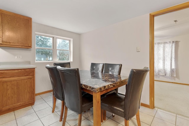 dining area with light tile patterned flooring, light carpet, and baseboards