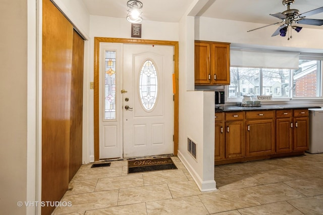 foyer featuring visible vents and ceiling fan