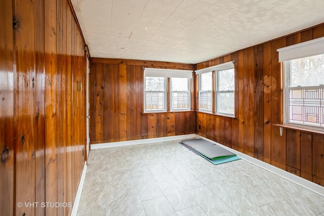 exercise area featuring baseboards and wooden walls