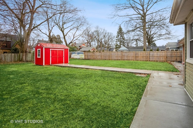 view of yard with a shed, an outdoor structure, and a fenced backyard