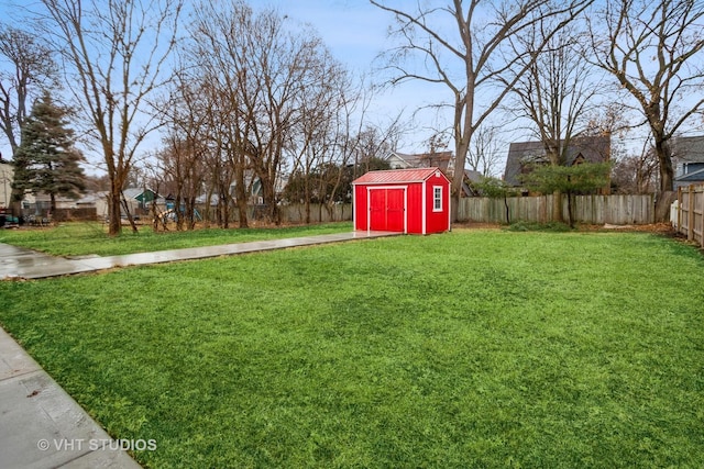 view of yard featuring an outbuilding, a fenced backyard, and a storage shed