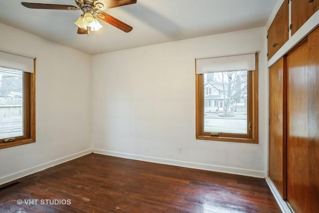 unfurnished bedroom featuring a ceiling fan, a closet, baseboards, and hardwood / wood-style floors