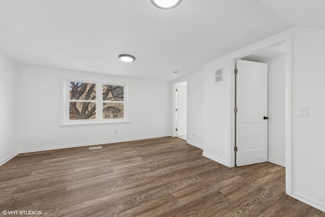 spare room with wood finished floors and baseboards