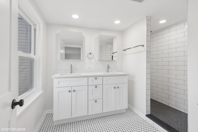 full bath featuring double vanity, a walk in shower, baseboards, and recessed lighting