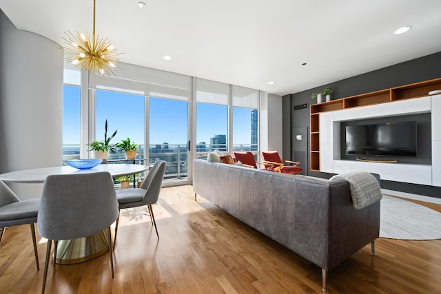 living area featuring a chandelier, floor to ceiling windows, recessed lighting, and light wood-style floors