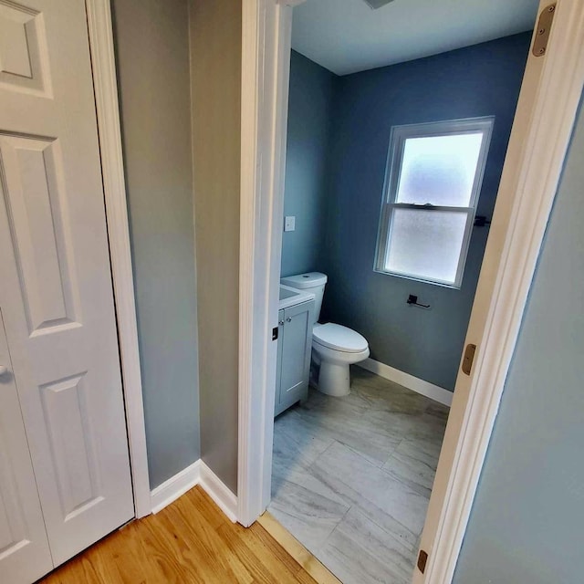 bathroom with vanity, toilet, and baseboards