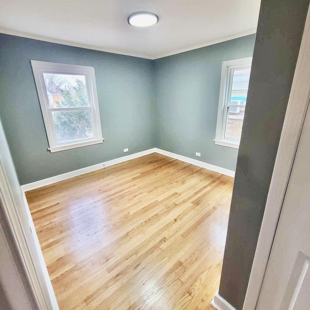 spare room featuring ornamental molding, wood finished floors, and baseboards