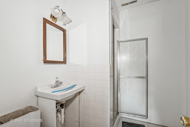 full bath with tile walls, visible vents, and a stall shower