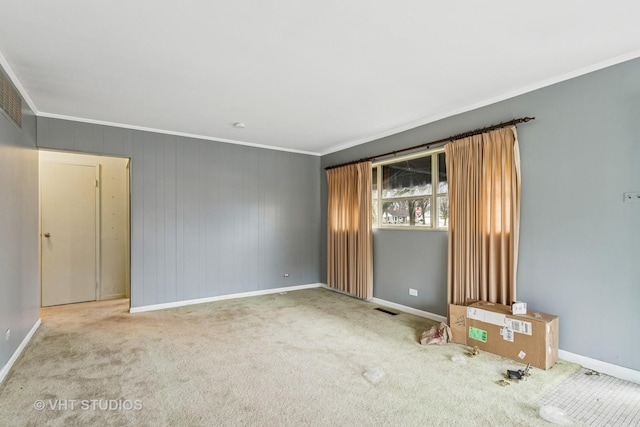 carpeted empty room featuring visible vents, baseboards, and ornamental molding