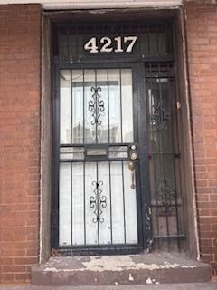 doorway to property featuring brick siding