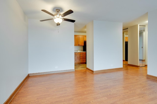 unfurnished living room with light wood finished floors, baseboards, and a ceiling fan