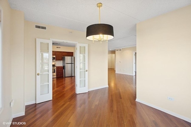 unfurnished dining area with french doors, baseboards, and dark wood-style flooring