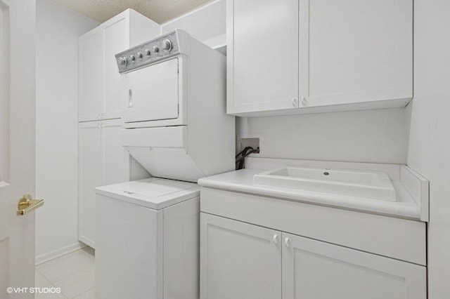 clothes washing area with stacked washer and dryer and a sink