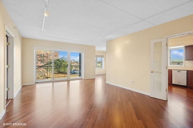 empty room with dark wood-style flooring and baseboards