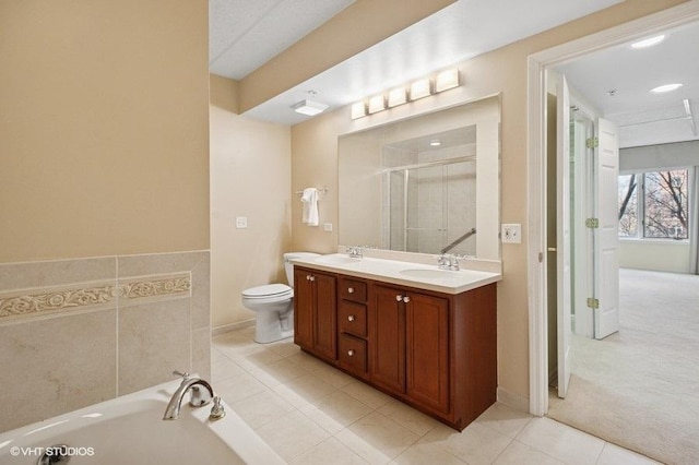 bathroom featuring a garden tub, double vanity, a stall shower, and a sink