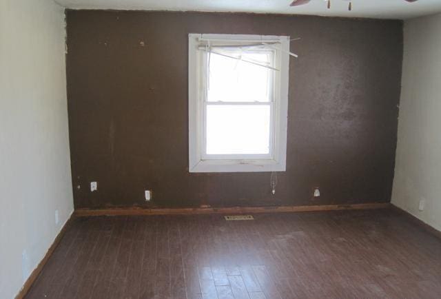 spare room featuring ceiling fan, a wealth of natural light, and wood finished floors