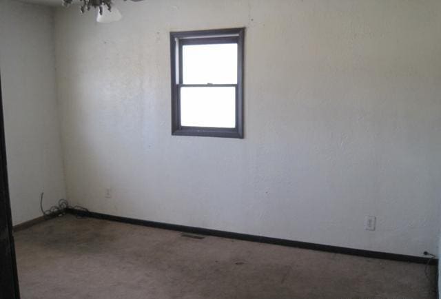 unfurnished room with baseboards