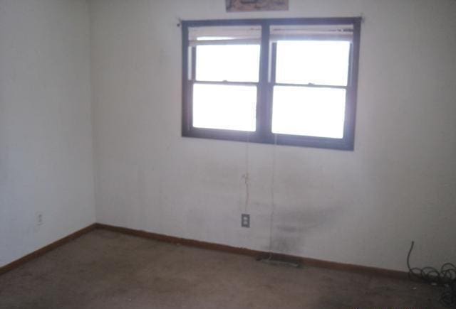 carpeted spare room with baseboards