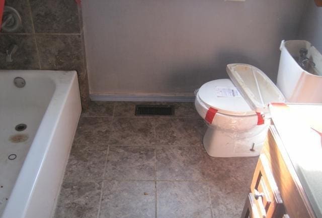 full bathroom with a bathtub, visible vents, toilet, baseboards, and tile patterned floors