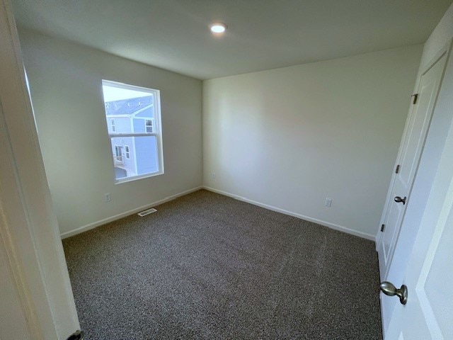 unfurnished bedroom featuring baseboards, visible vents, dark colored carpet, and recessed lighting