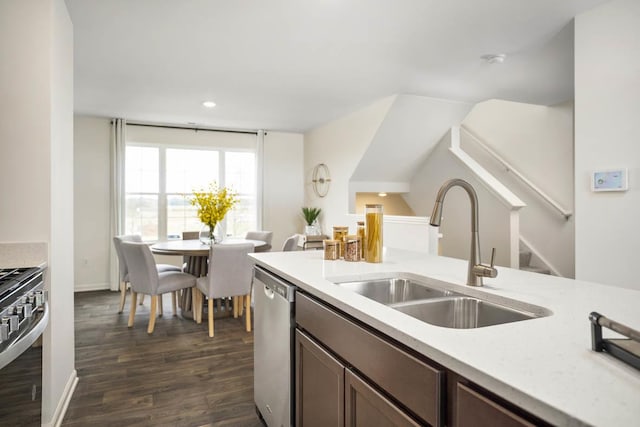 kitchen with dark wood-type flooring, stainless steel appliances, a sink, and light countertops