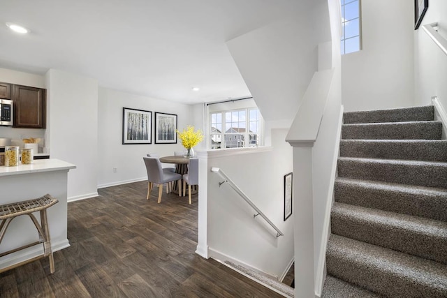 staircase with recessed lighting, wood finished floors, and baseboards