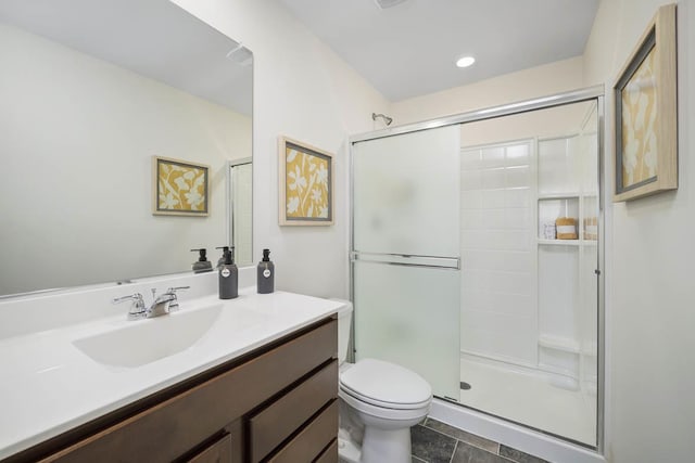 full bathroom with toilet, vanity, and a shower with shower door