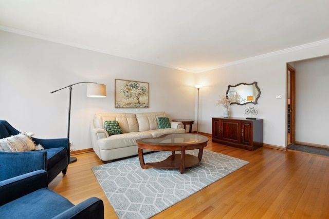 living area with ornamental molding, baseboards, and wood finished floors