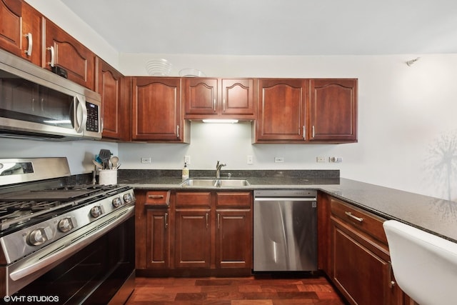 kitchen featuring stainless steel appliances, dark wood-type flooring, and a sink