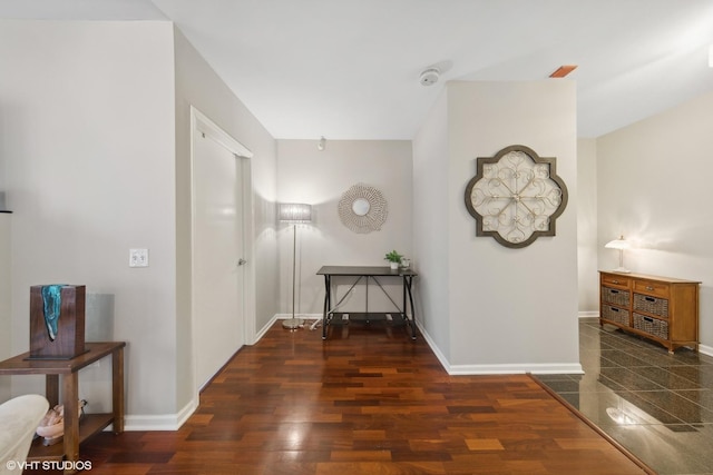 corridor with baseboards and wood finished floors