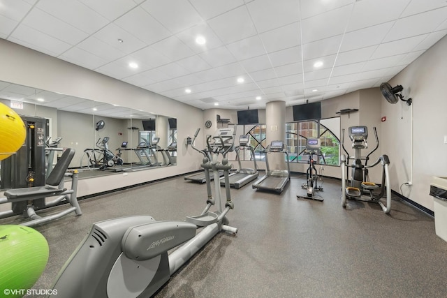 gym with baseboards, a drop ceiling, and recessed lighting