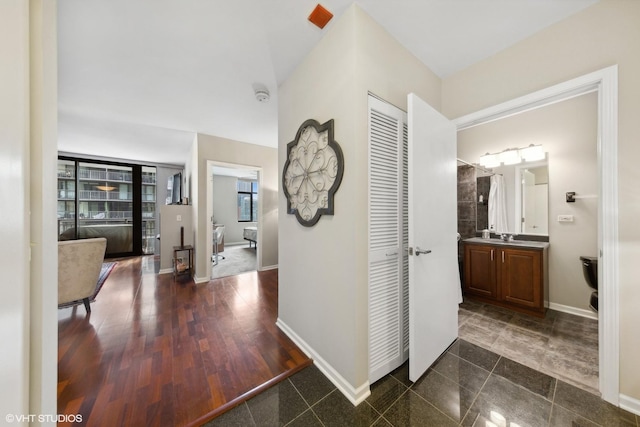 hall with baseboards and wood finished floors