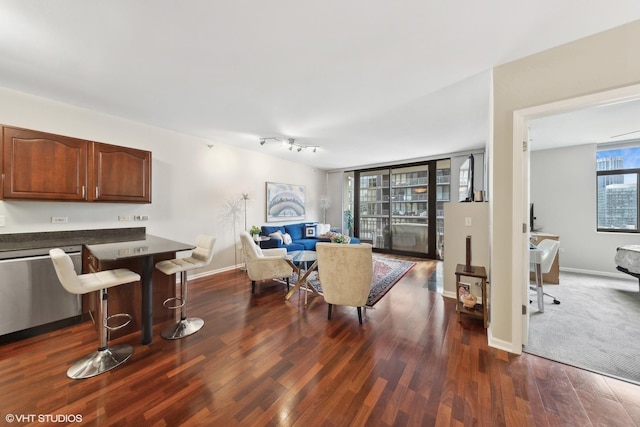 dining area featuring dark wood-style flooring and baseboards