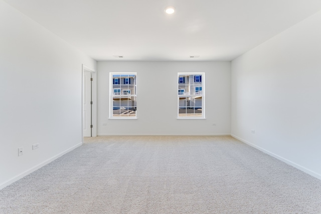 unfurnished room featuring baseboards and light colored carpet