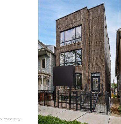 view of front facade with a fenced front yard, a gate, and brick siding