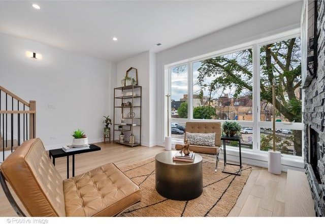 interior space with recessed lighting, a fireplace, stairway, and wood finished floors