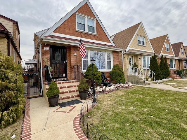 view of front facade featuring a gate, brick siding, and a front lawn