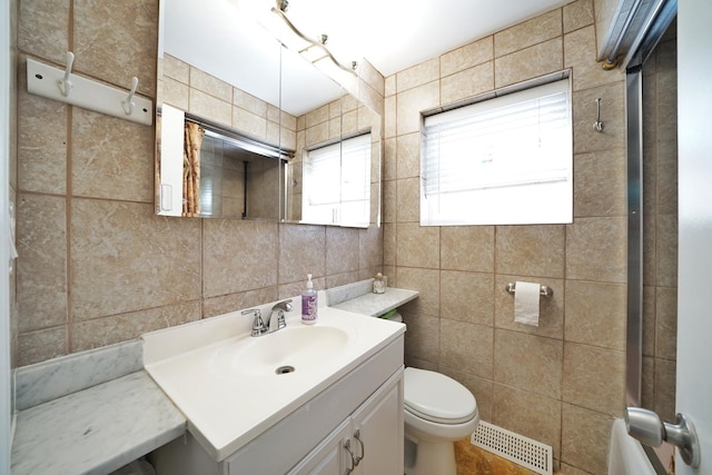 bathroom featuring tile walls, visible vents, vanity, and toilet