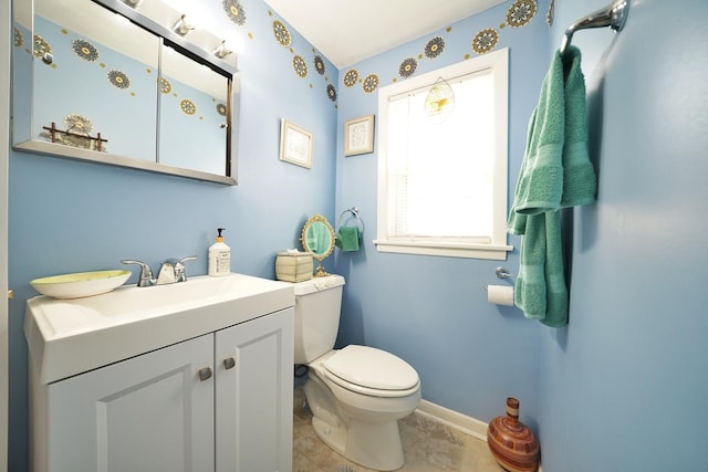 half bath featuring toilet, tile patterned floors, baseboards, and vanity